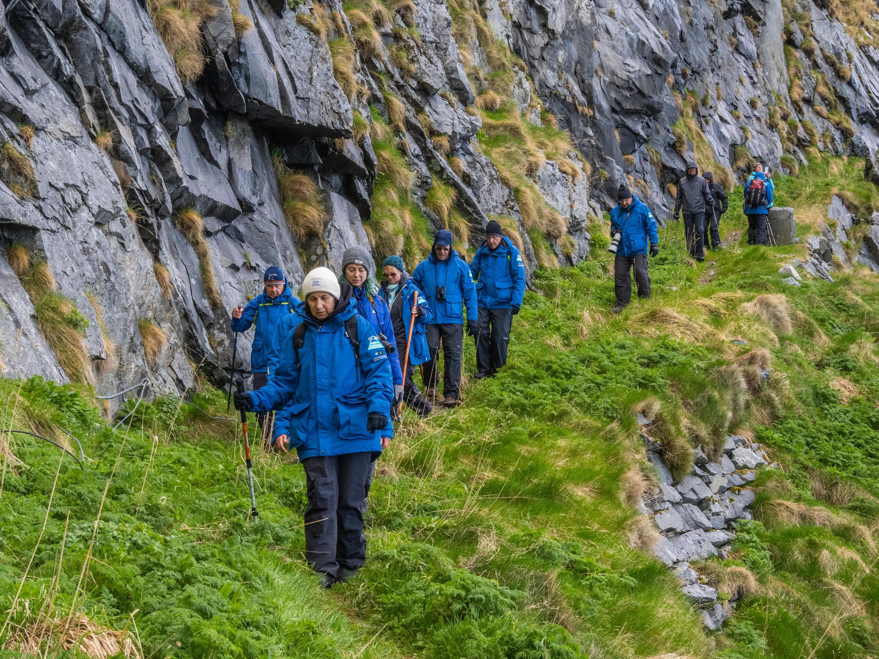 Lindblad Expeditions guests on a hike in the summer only former fishing village of Mastad, on the island of Vaeroya, Norway.