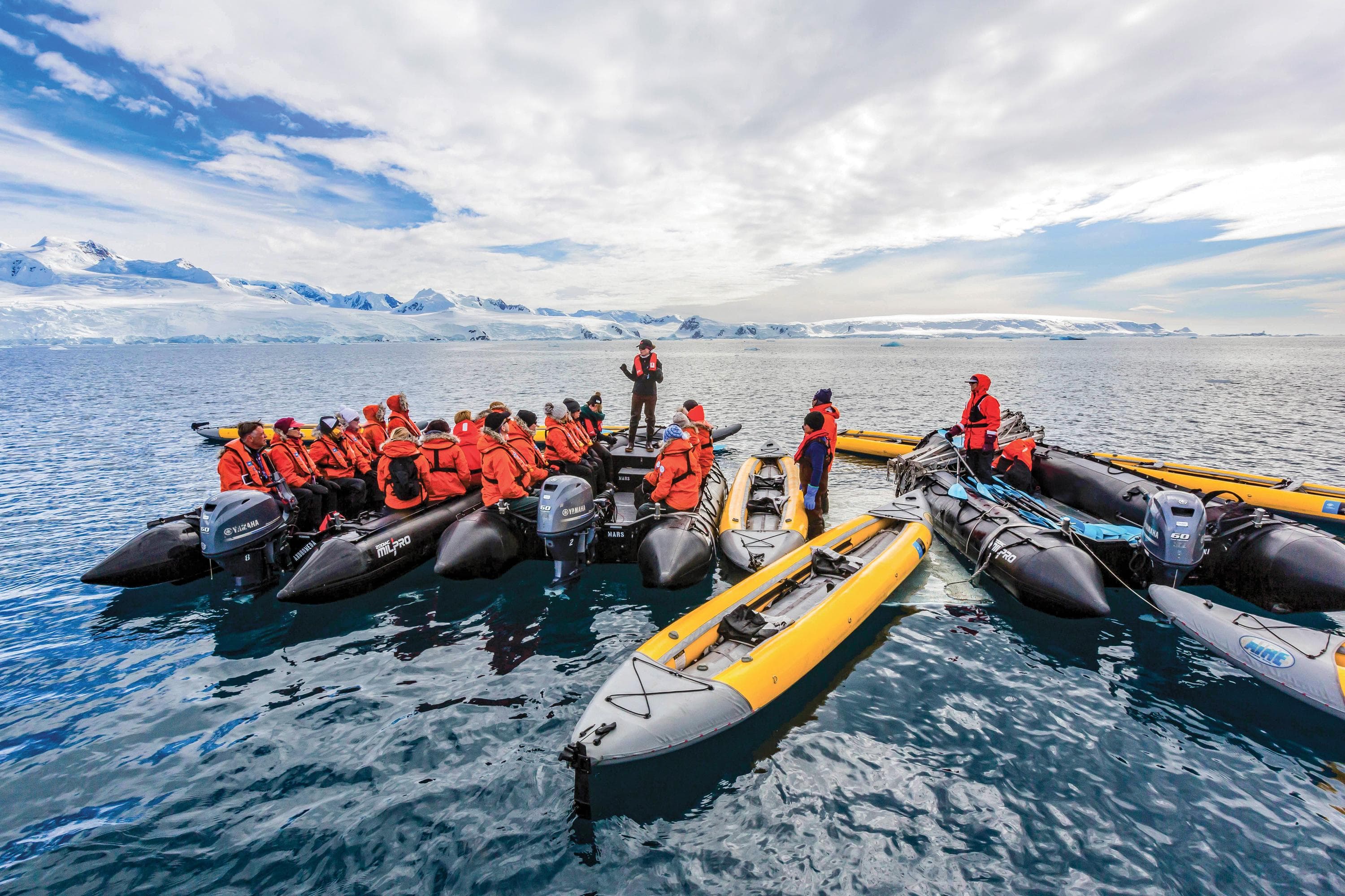 Lindblad staff talk to guests as they prepare to explore by kayakys in Antarctica.