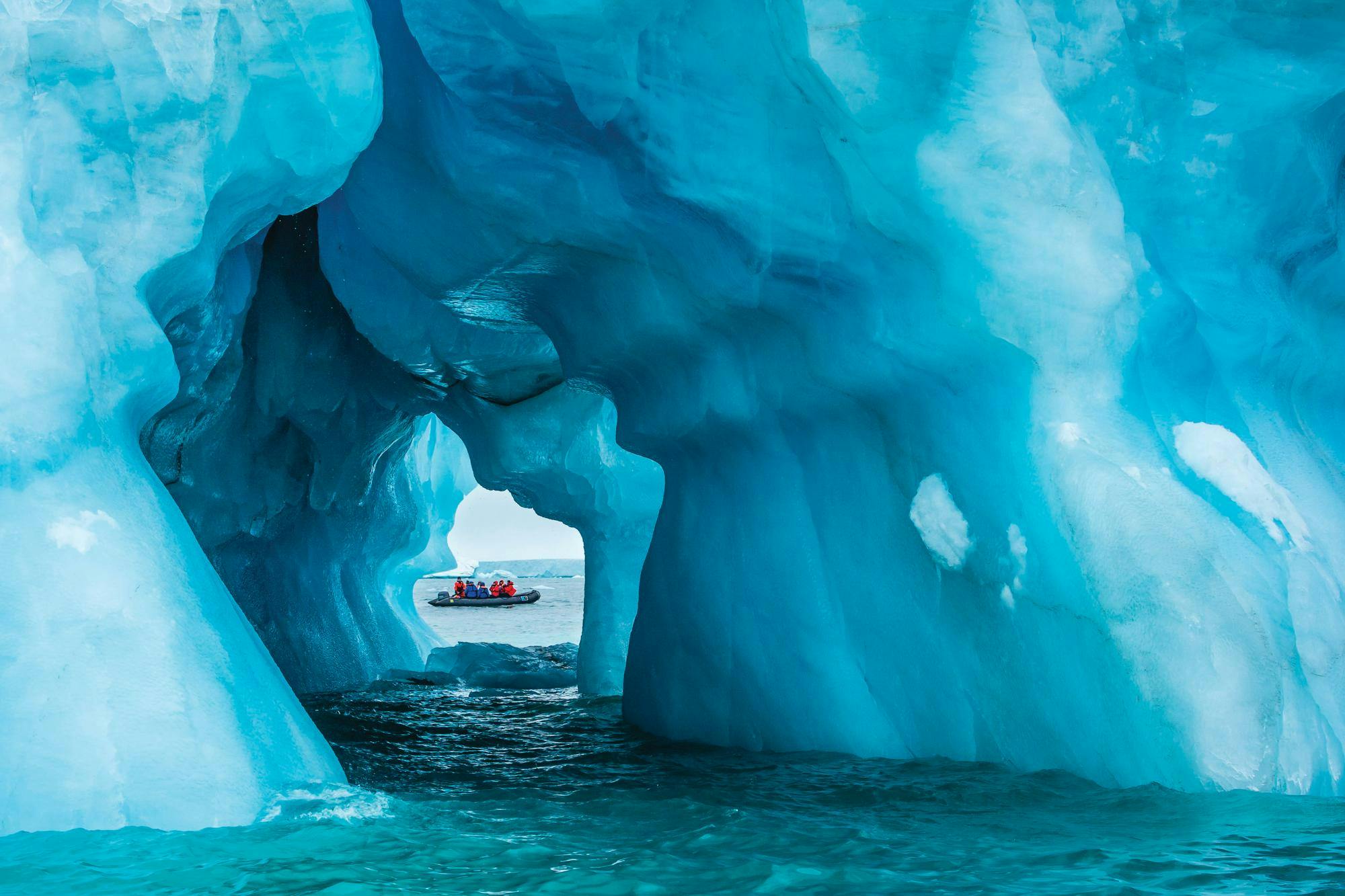 Guests explore a sea ice cave by zodiac in Queens Bay, Philpots Island, Lancanster Sound, Canada, Northwest Passage