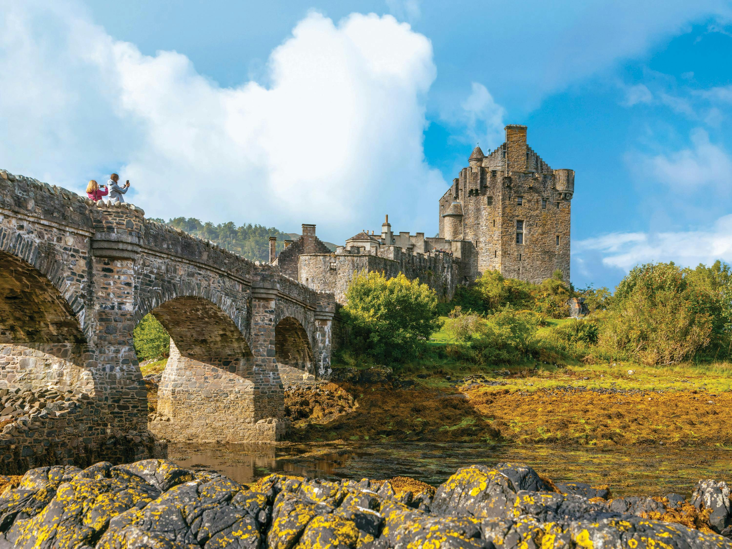 Guests take photographs of Eilean Donan Castle, a favorite guest location, in Loch Duich, Highland, Scotland.