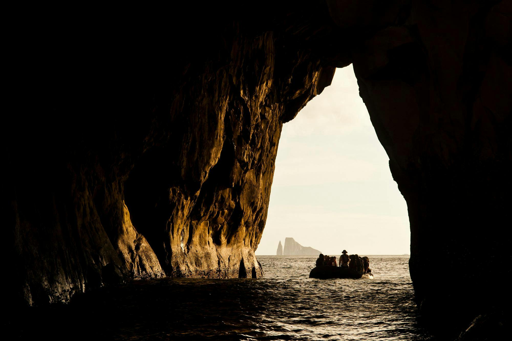 Guests adventure by zodiac in the rocky arch at Kicker Rock, San Cristobal Island, Galapagos Islands, Ecuador