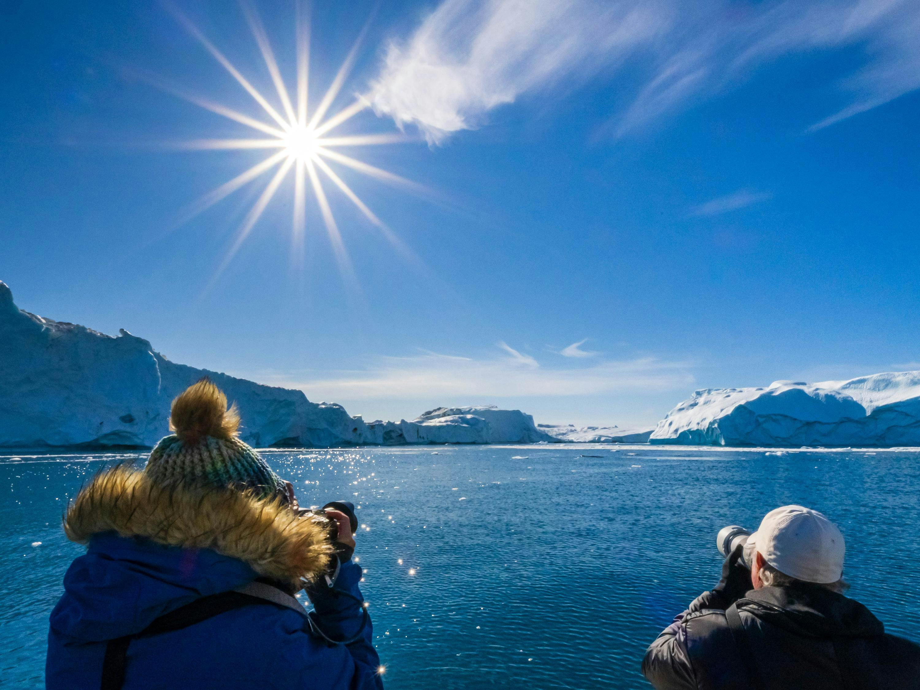 Guests photographing giant icebergs in Icefjord, Ilulissat, Greenland