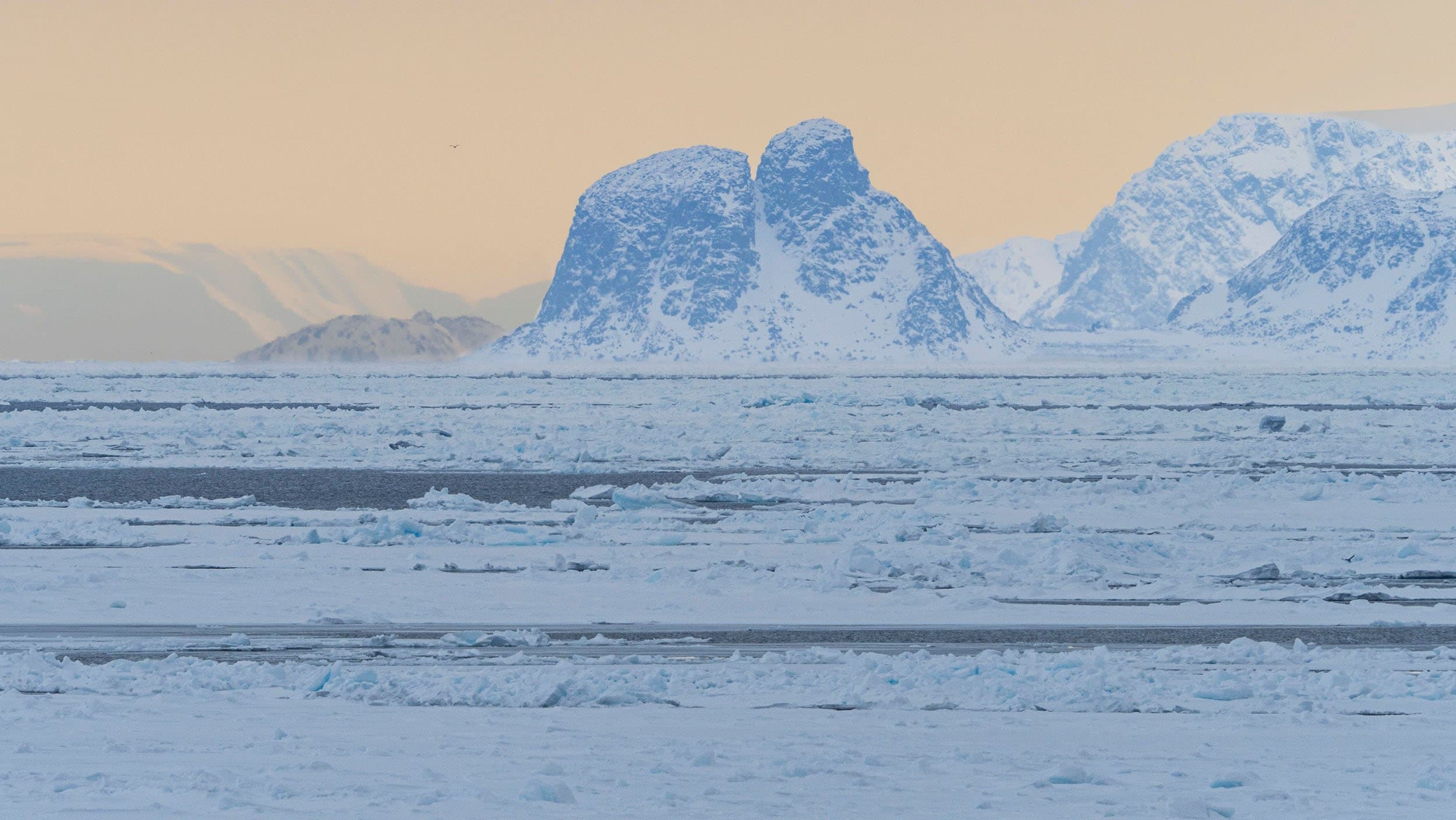 a pink sunset over arctic ice