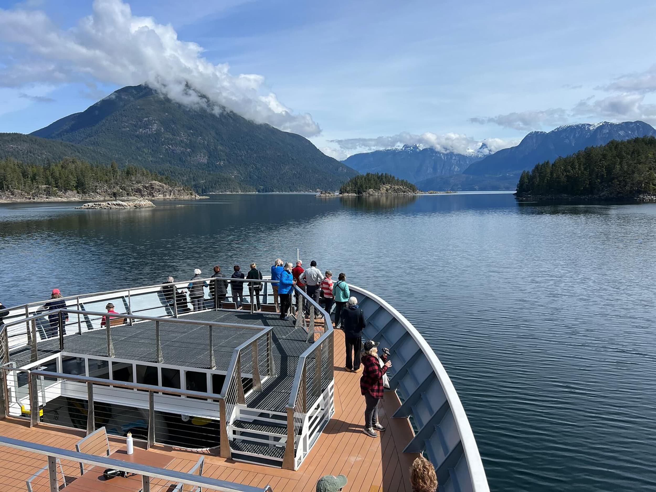 guests standing on the bow of a ship in Alaska
