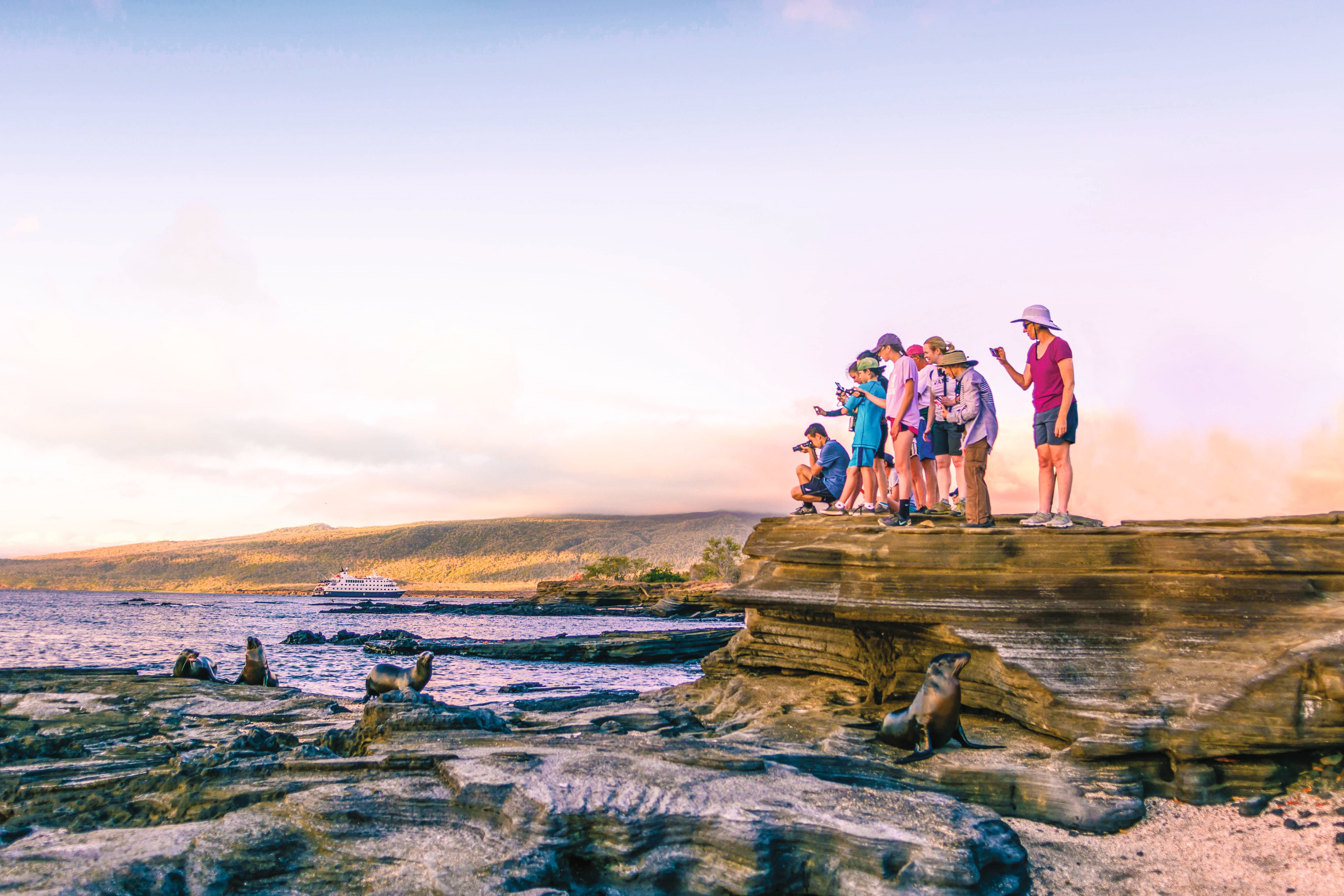 Family taking a photo of sea lions in Galápagos.