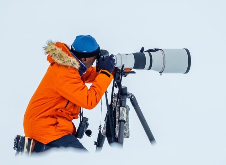 A man using a long lens to photograph polar landscape