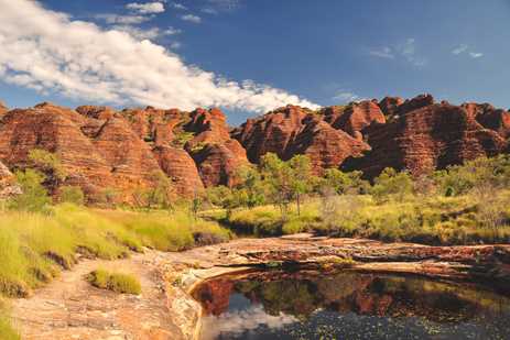 A range of reddish brown mountains or hills, curiously shaped and streaked with horizontal ridges