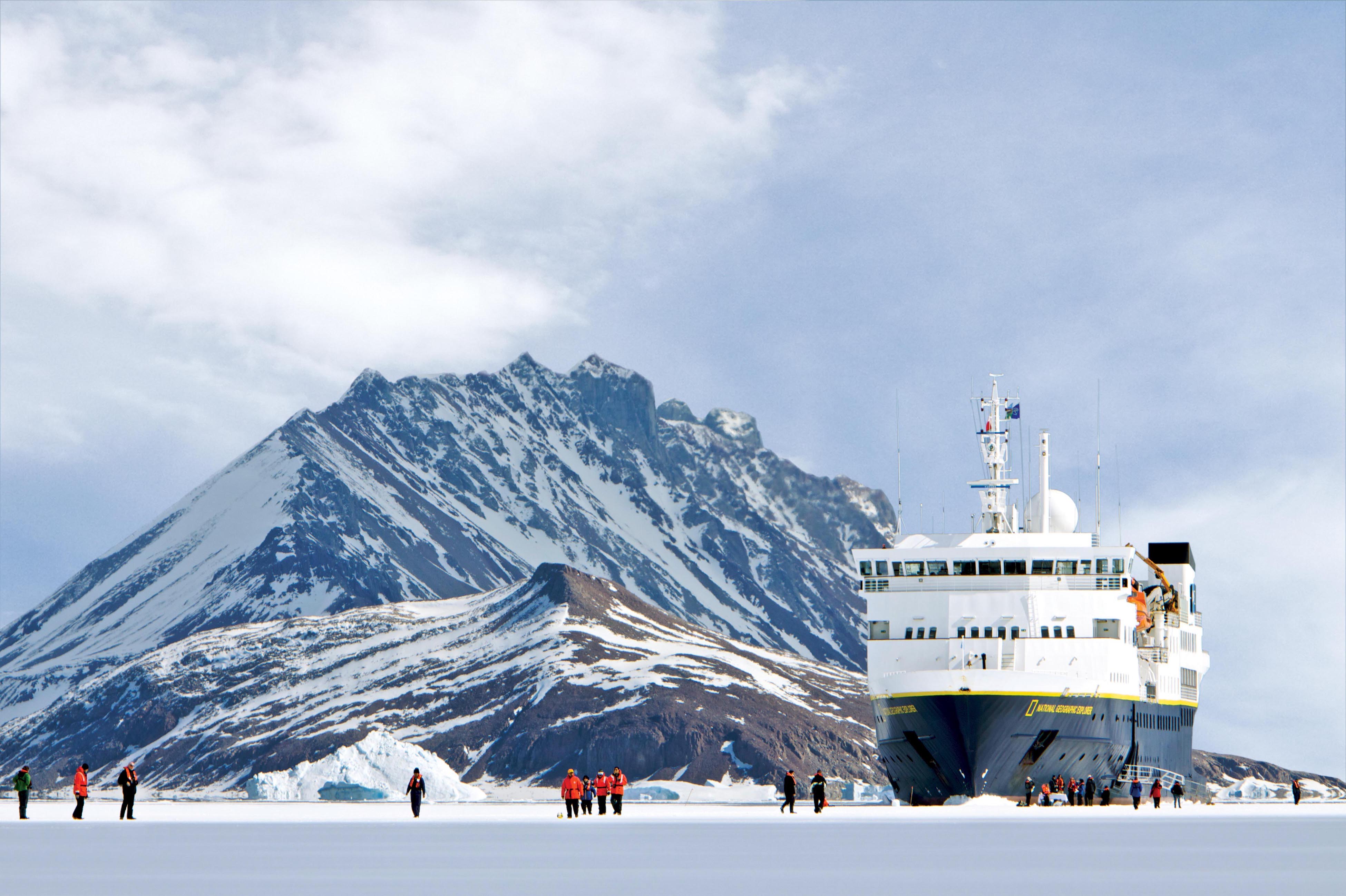 Guests walk on a frozen sea in Antarctica