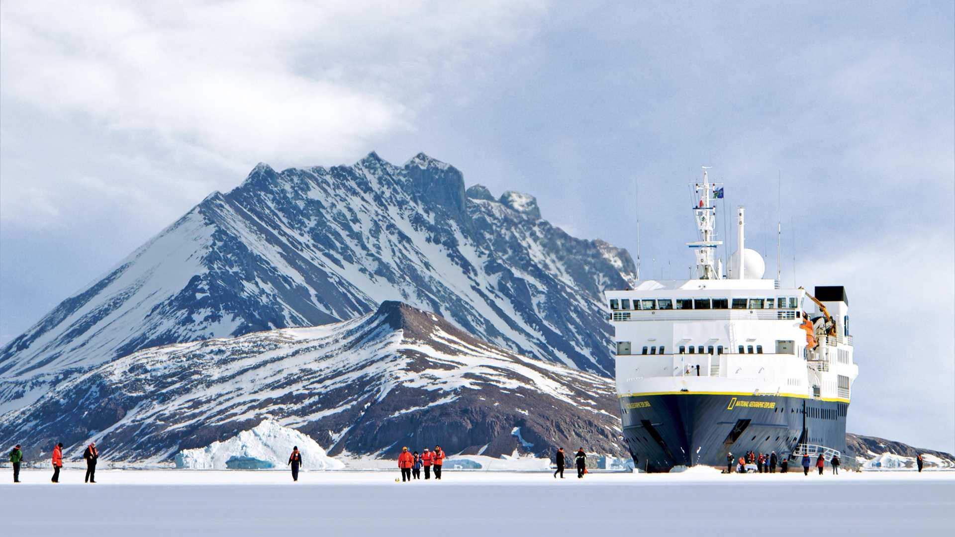 Guests walk on a frozen sea in Antarctica