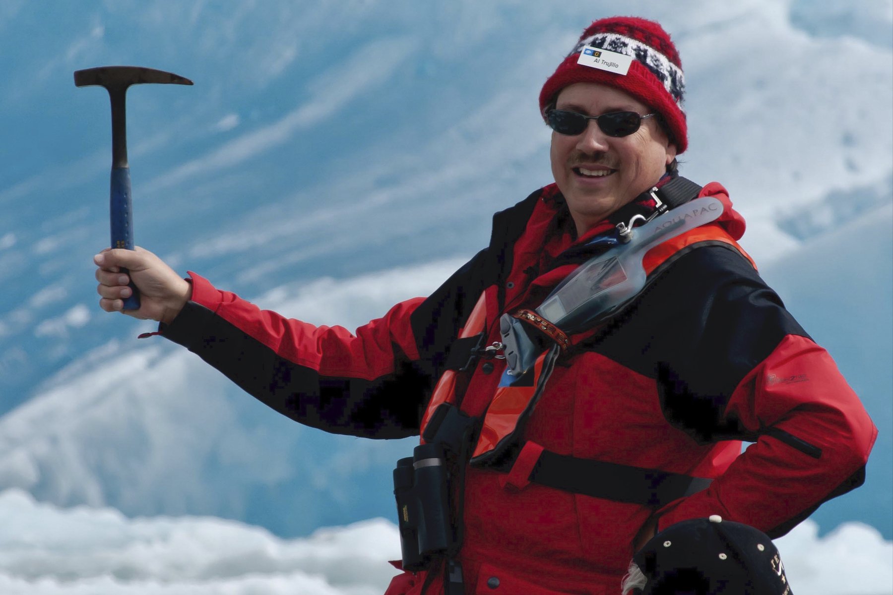 Man holding a pickaxe in front of an Alaskan glacier
