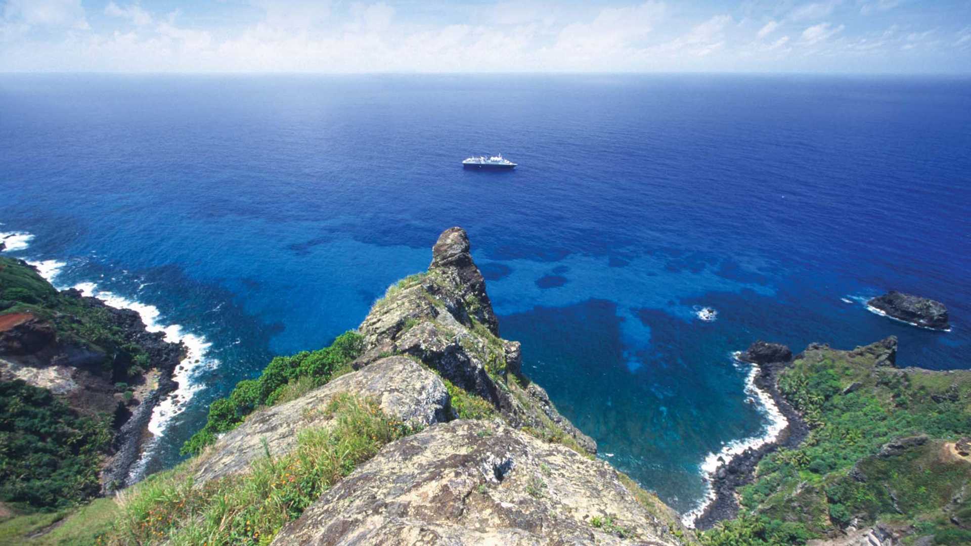A Lindblad expedition ship anchors off the coast of Pitcairn Island