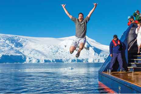 A man jumps into the polar waters on a Lindblad-National Geographic expedition