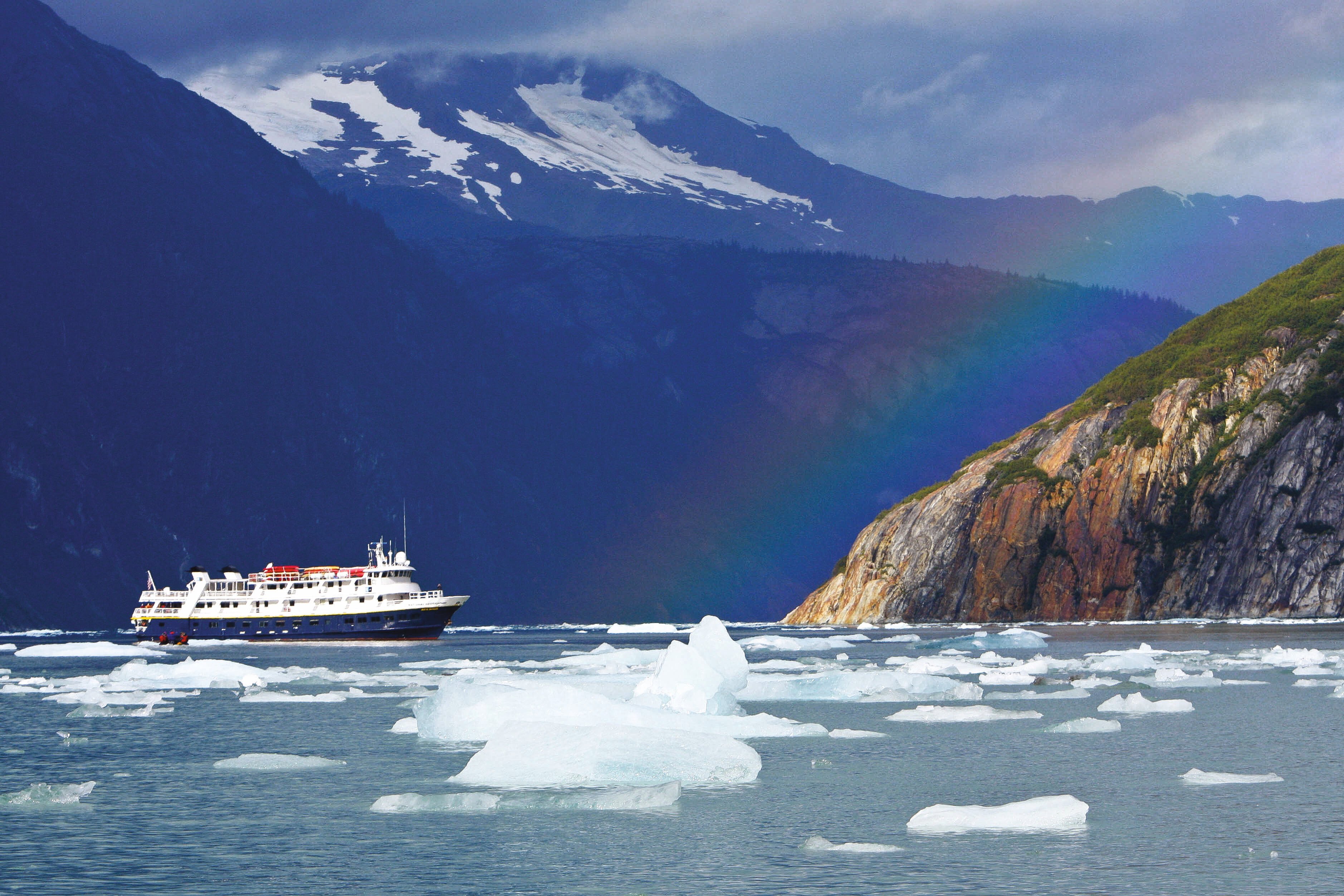 Guests explore by zodiac from the ship National Geographic Sea Bird among rainbows and icebergs in remote Endicott Arm, Alaska.