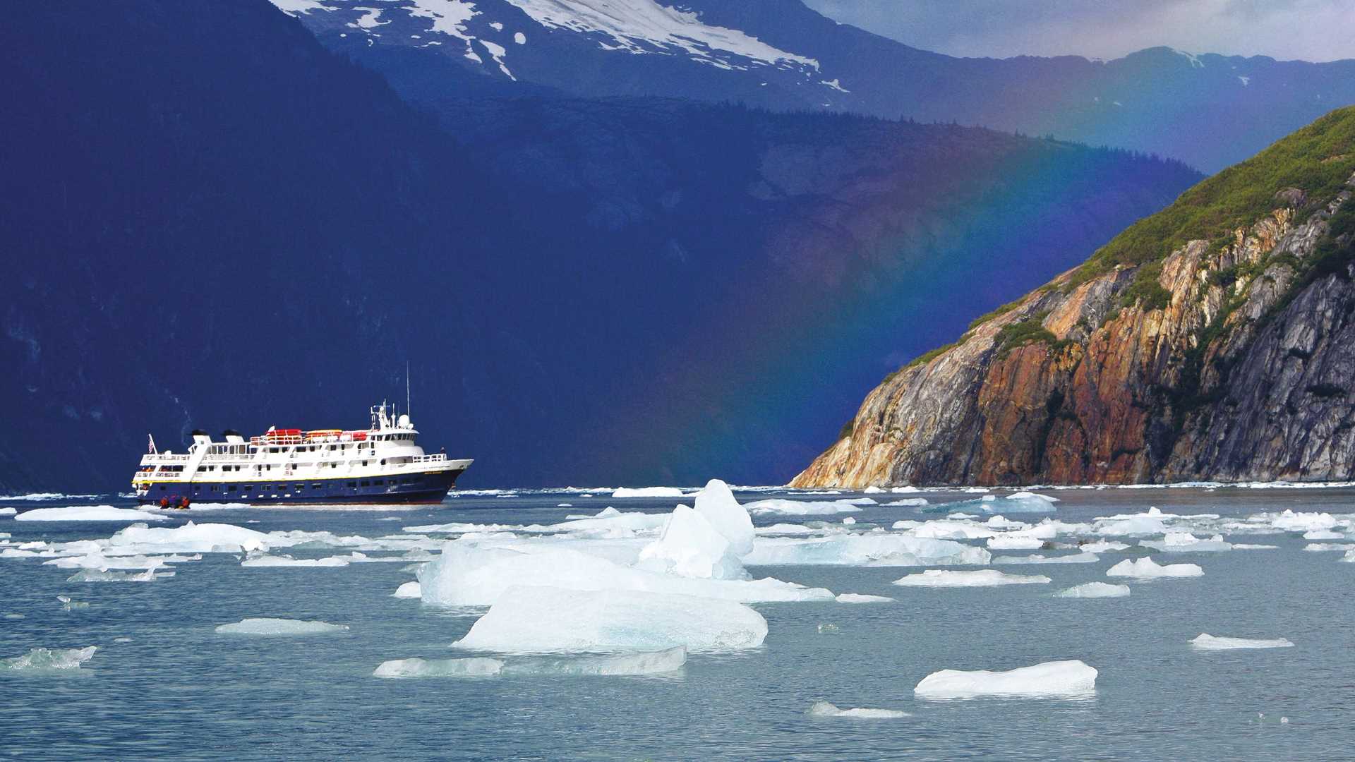 Guests explore by zodiac from the ship National Geographic Sea Bird among rainbows and icebergs in remote Endicott Arm, Alaska.