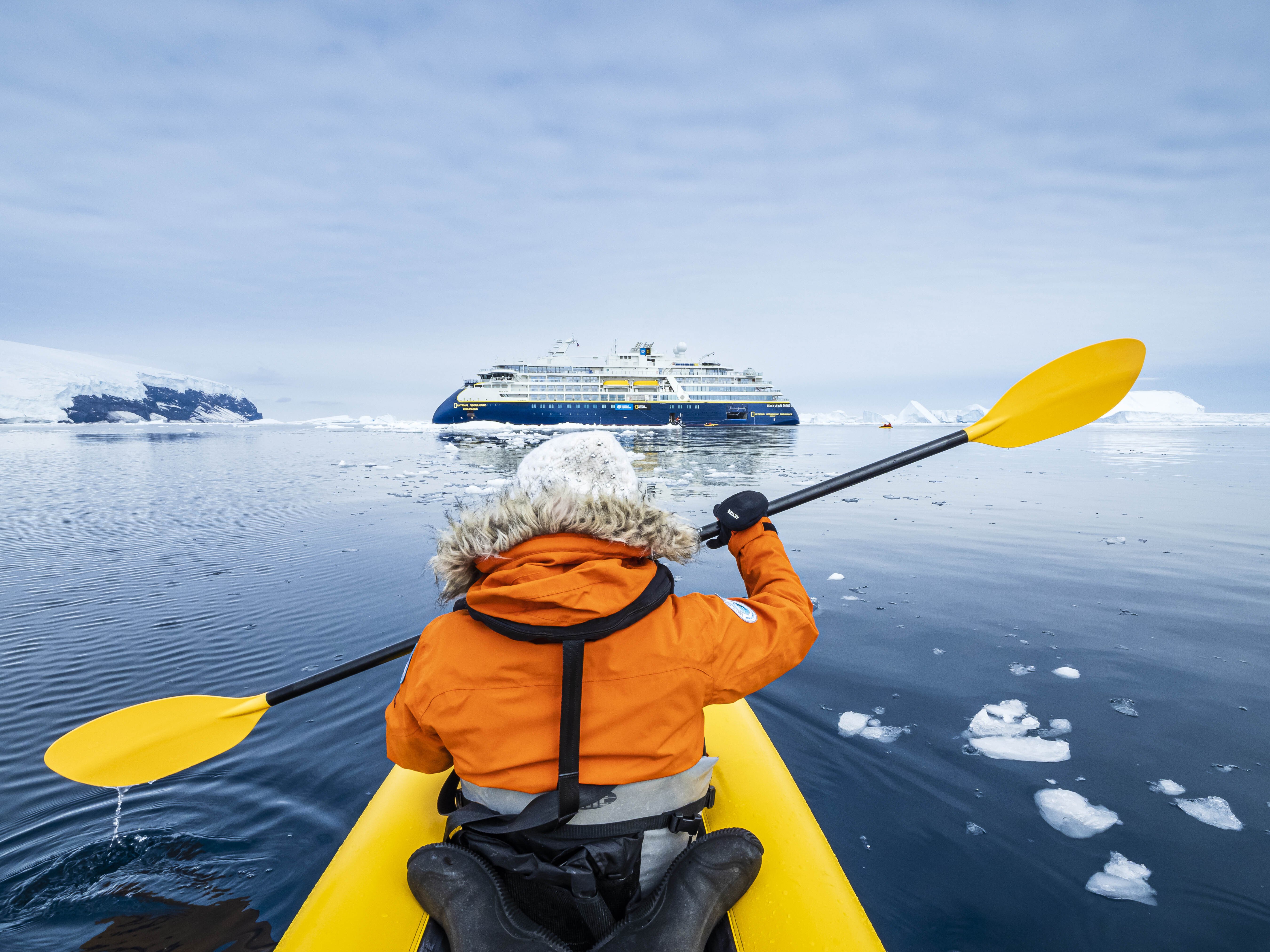 A kayaker paddles in Antarctica with the National Geographic Resolution.