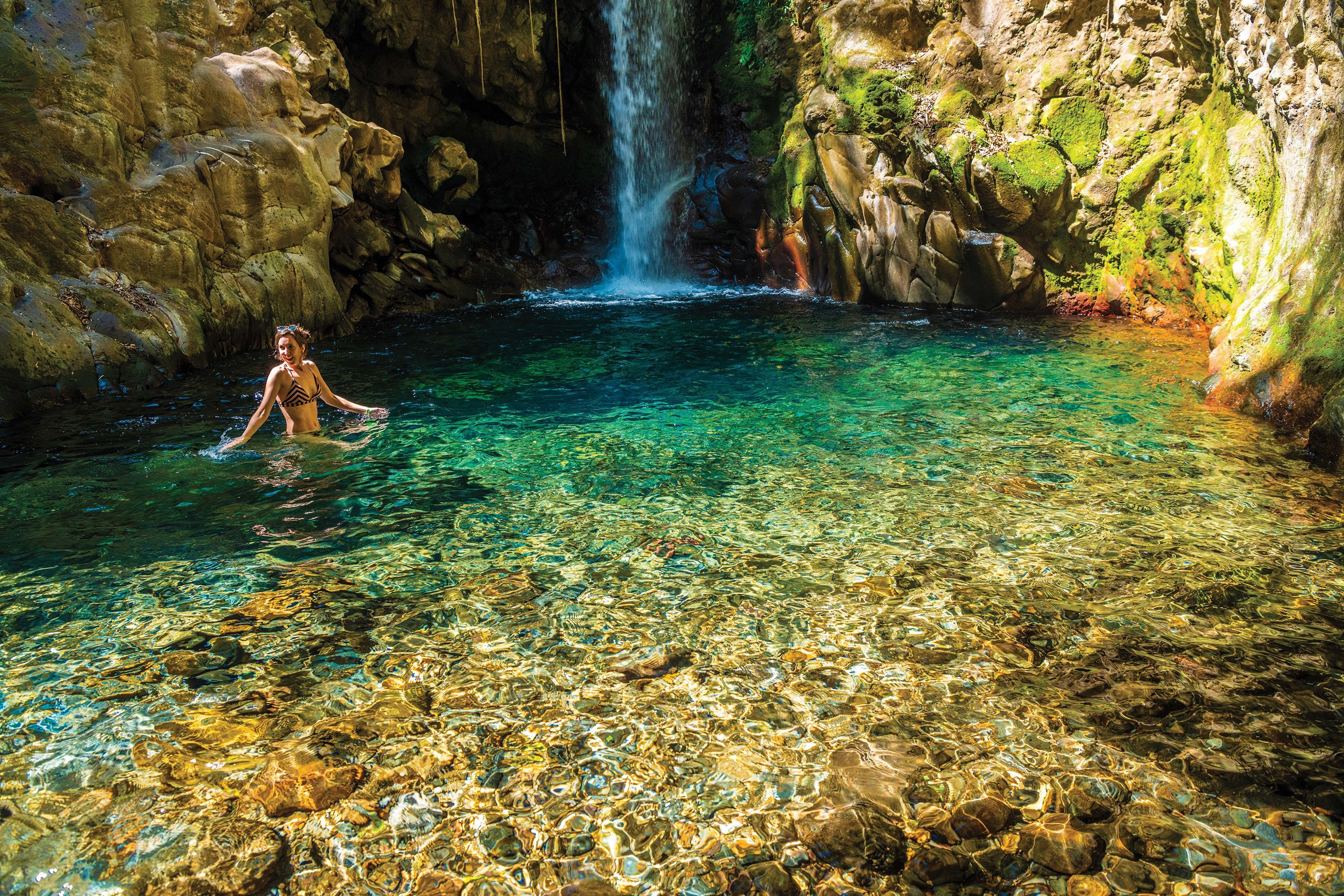 Woman swimming in a waterfall pool in Guanacaste, Costa Rica.