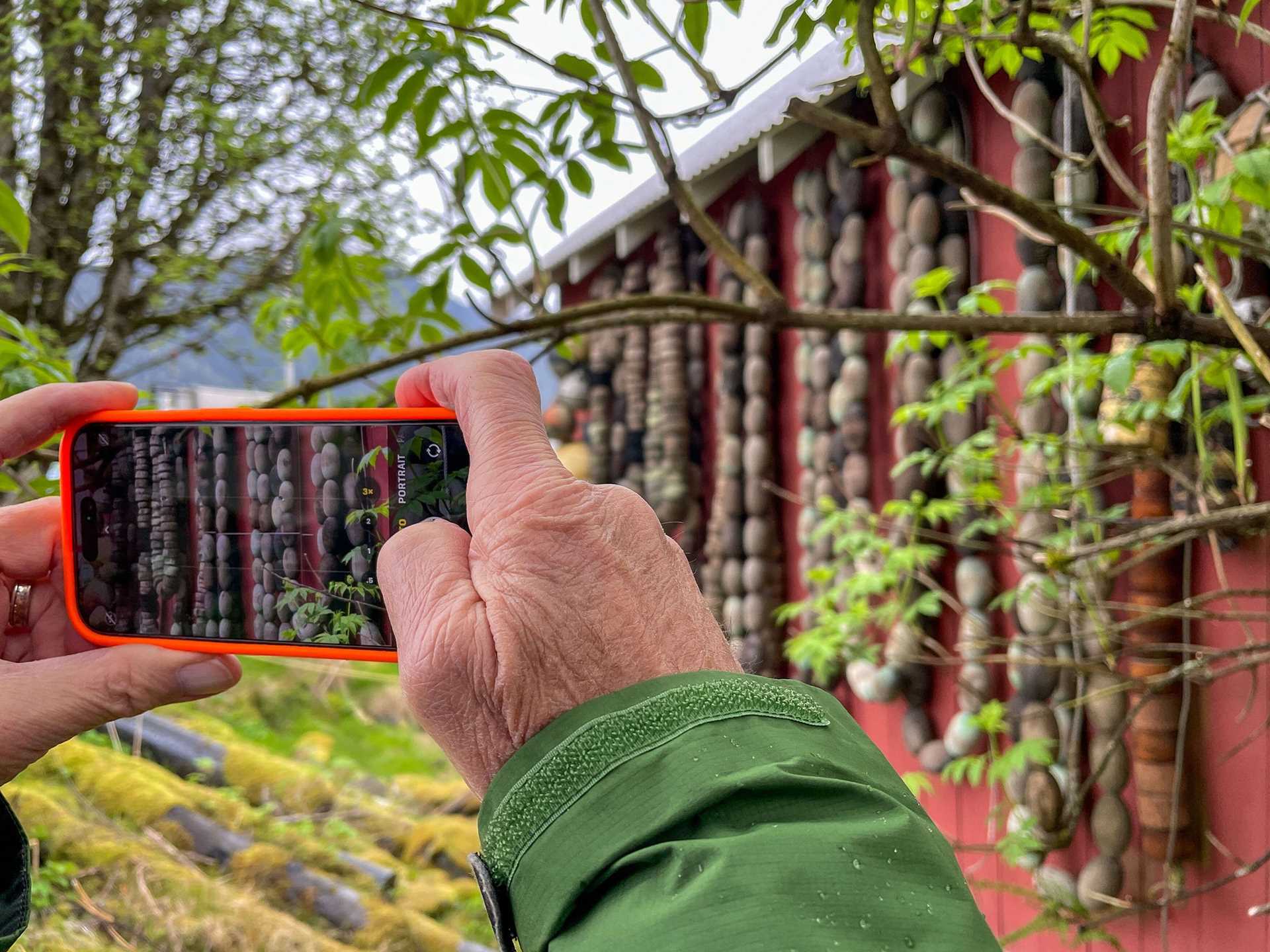 a person takes a photo of a barn with a phone