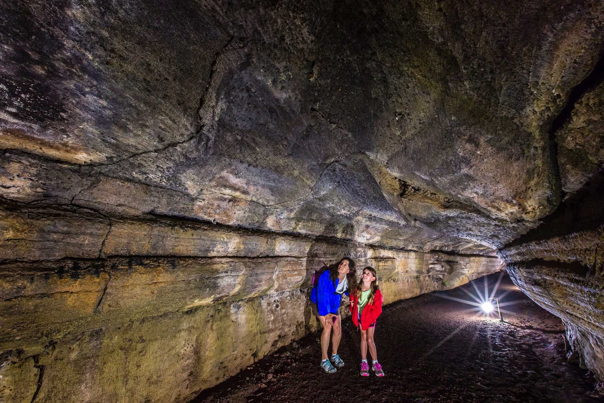 A mother and daughter explore a lava tunnel on Santa Cruz Island.