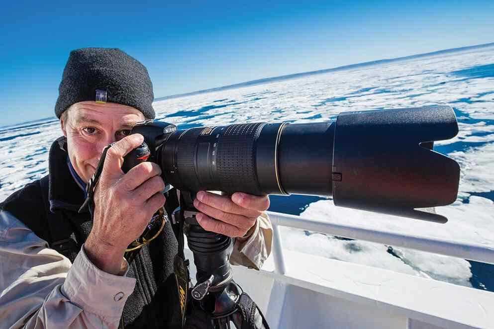 National Geographic Photography Expert Rich Reid poses while taking a photo.