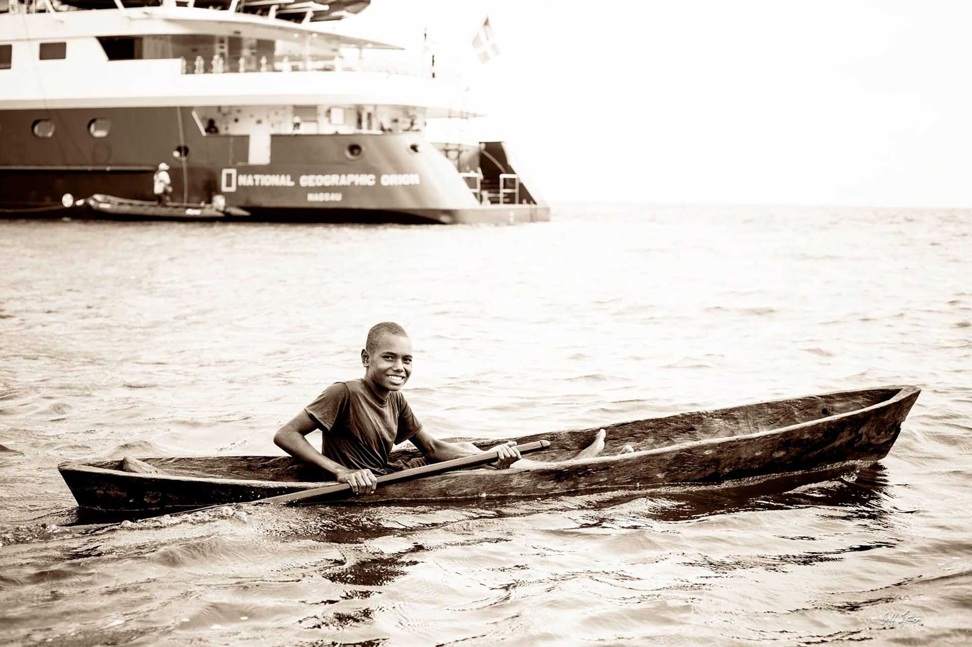 a boy paddling a canoe